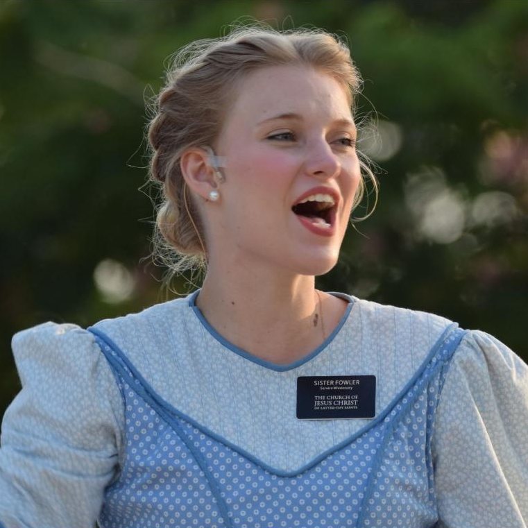 Paige singing outdoors in a blue pioneer dress